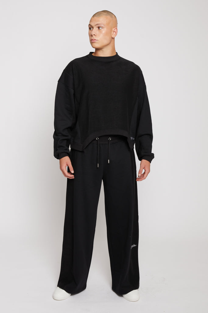 A model showing the oversized fit of the men's black crew neck jumper.