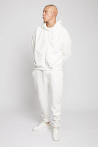 A model wearing the full men's white tracksuit with tapered joggers.