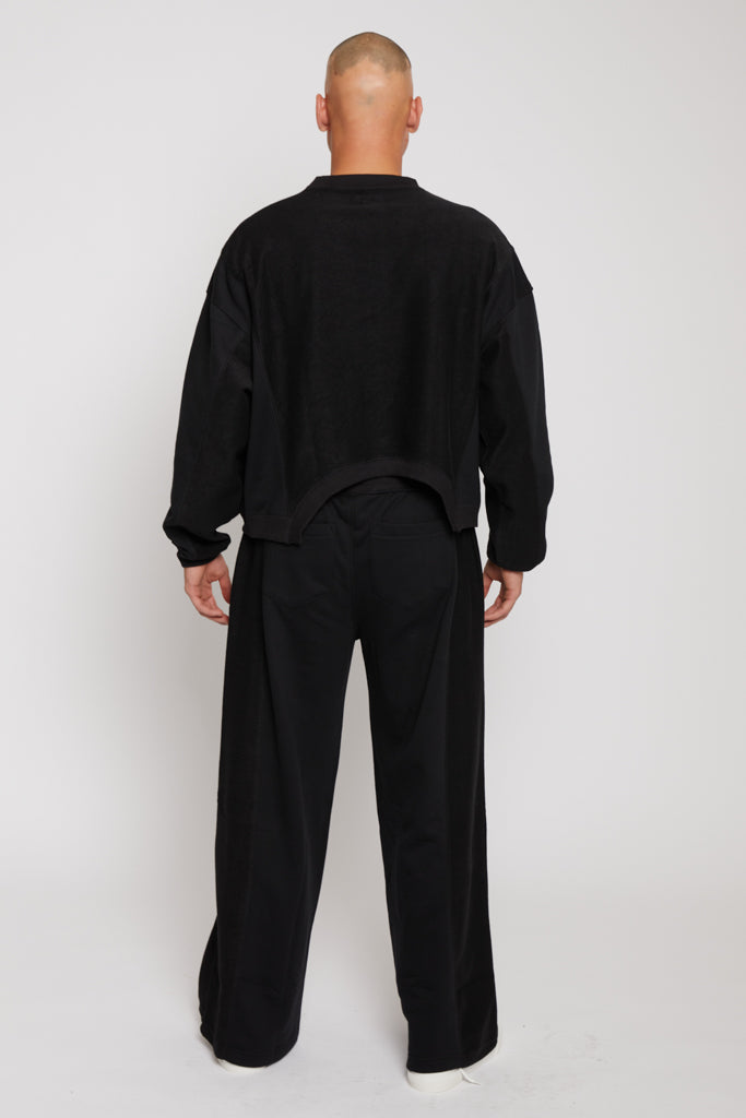 Back view of a model wearing the oversized men's black crew neck jumper.