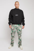 A model wearing the men's black crew neck jumper with a white front logo.