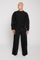 Full length view of model in mens black wide leg joggers mixed fabric set