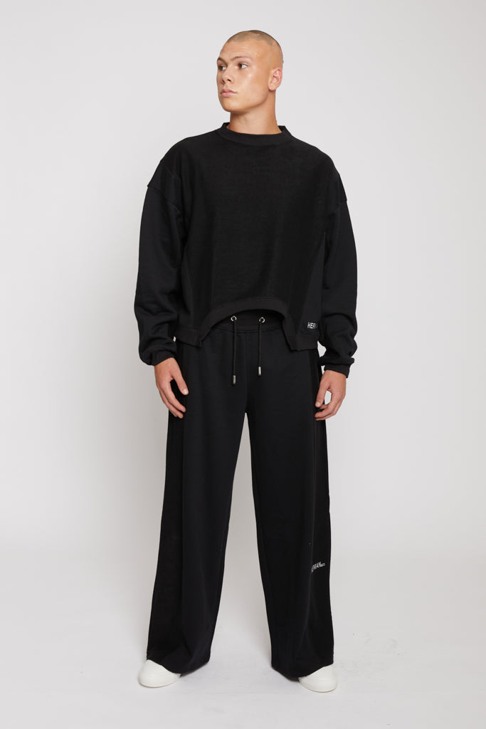 Full length view of model in mens black wide leg joggers mixed fabric set
