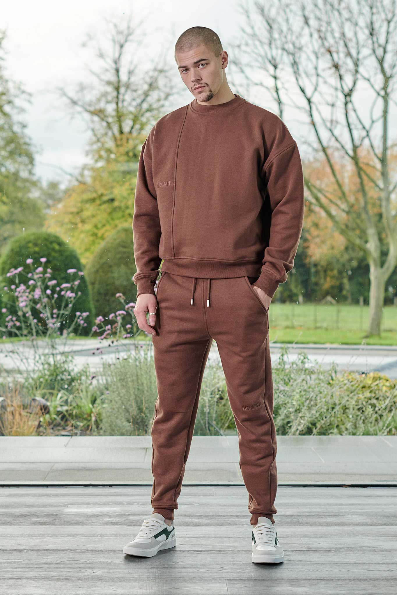 A model wearing the men's brown crew neck jumper with matching joggers.