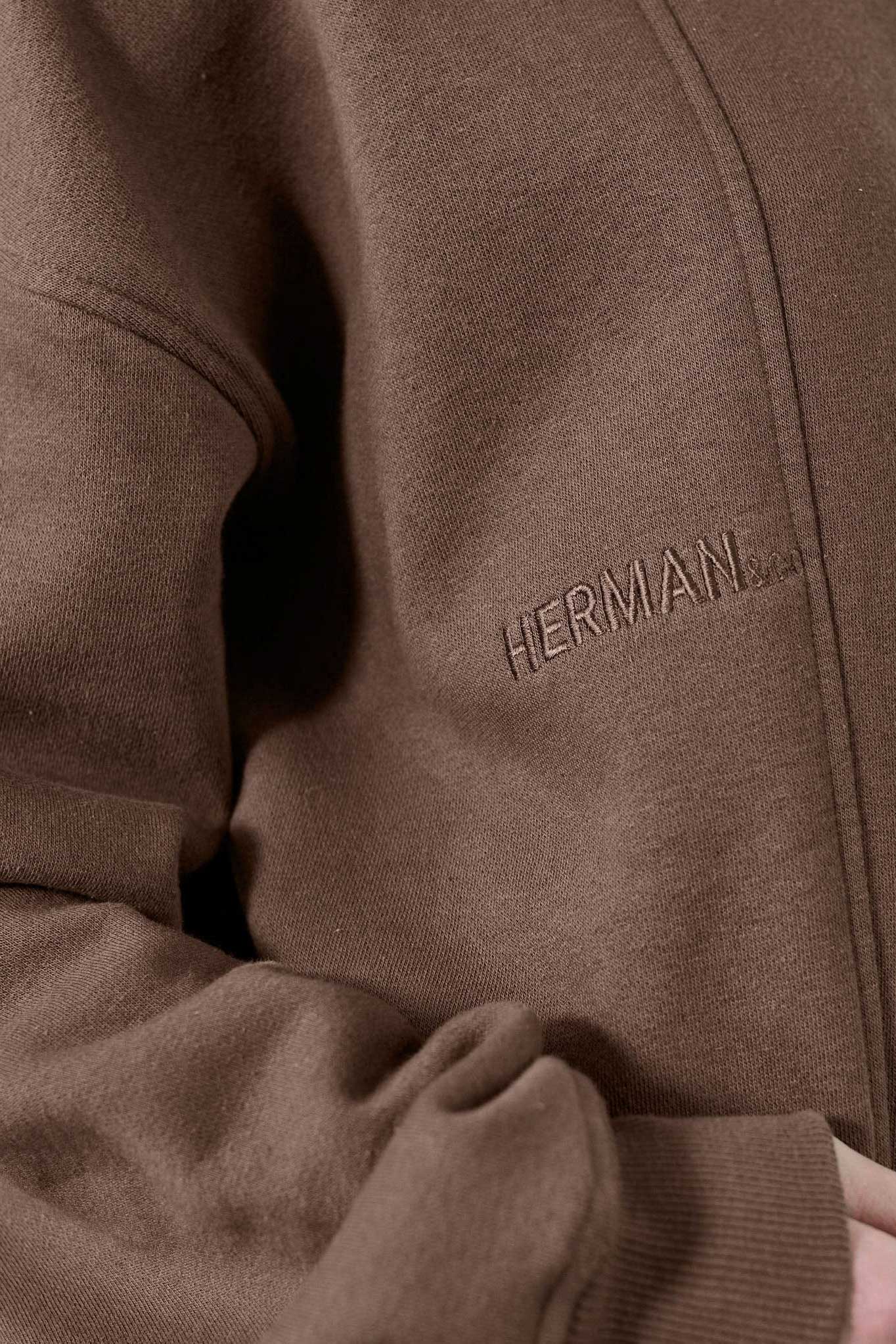 Detailed view of the shoulder stitching on the men's brown crew neck jumper.