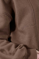 Detailed view of the shoulder stitching on the men's brown crew neck jumper.