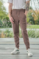 Close-up of the men's brown tapered joggers showing the fit and cuffed ankle.
