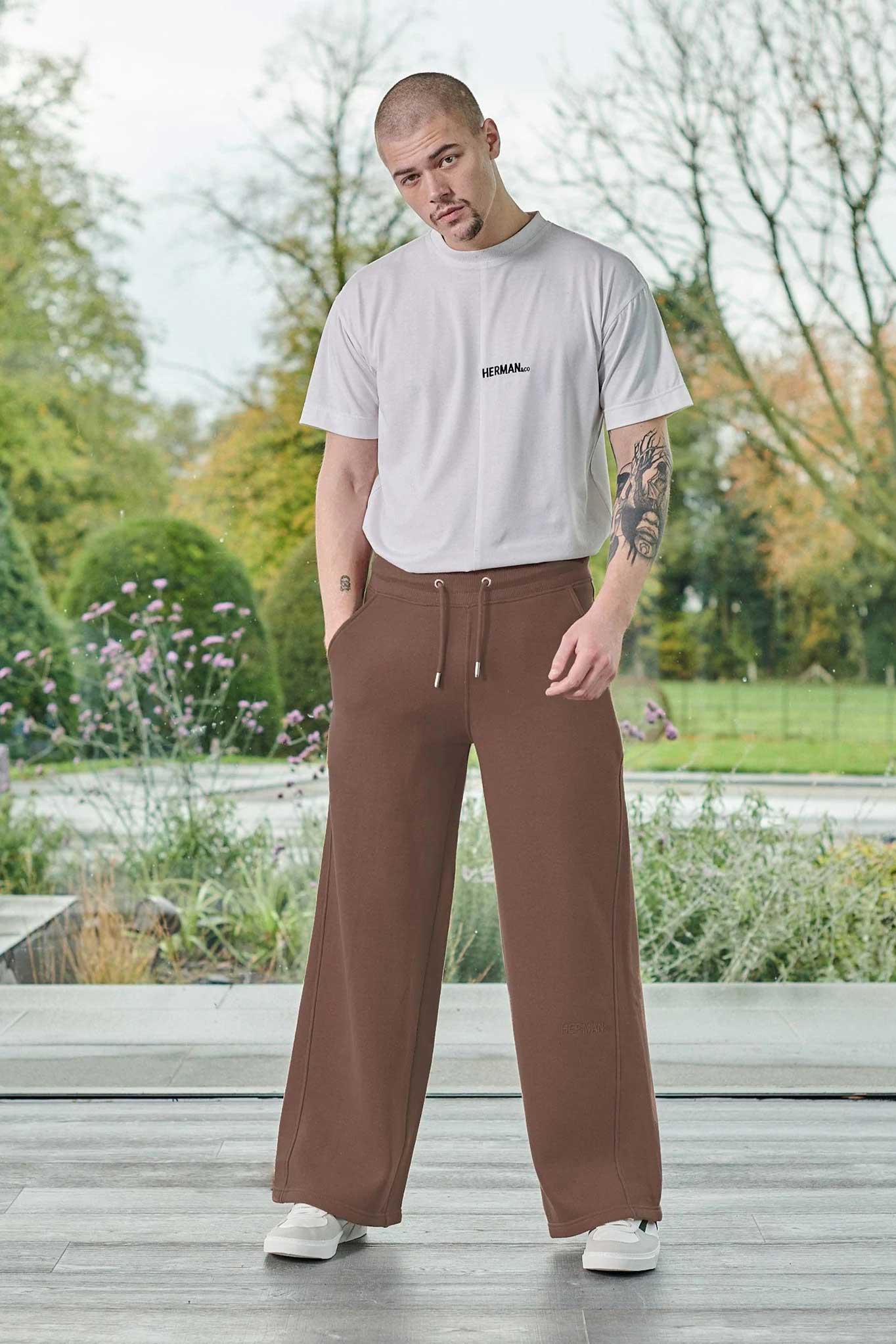 A model wearing the men's brown wide-leg joggers with a white t-shirt