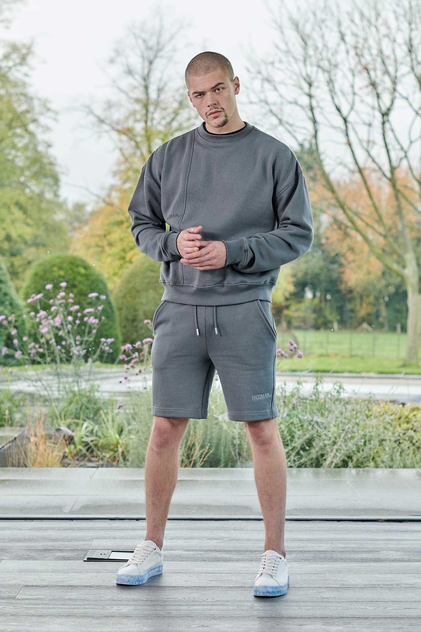 Full length front view of mens cool grey jumper styled with matching shorts