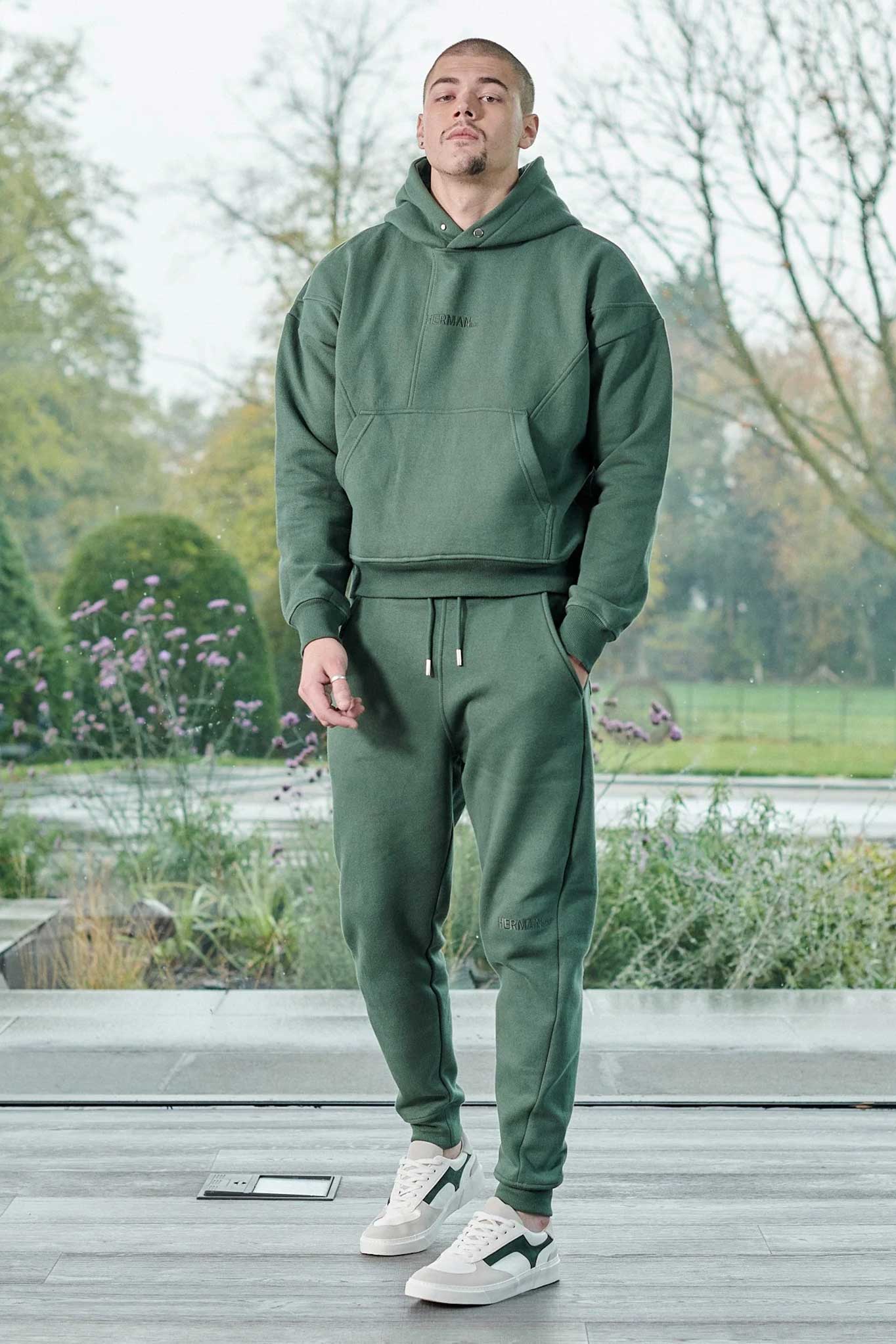 Full length view of model walking in mens dark green hoodie casual outfit