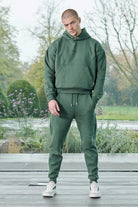 Front view of model wearing mens dark green hoodie with matching joggers