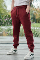 Close-up of the men's dark red tapered joggers showing the fit and tonal logo.