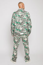 Back view of a model in the men's green psychedelic print jacket and matching trousers.