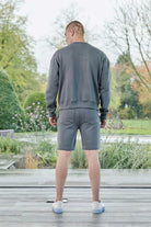 Rear view of mens grey crew neck jumper showing back fit