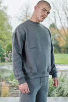 Side profile view showing the relaxed fit of mens grey crew neck jumper