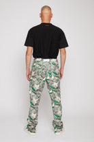 Back view of a model in the men's jeans with a green psychedelic print.