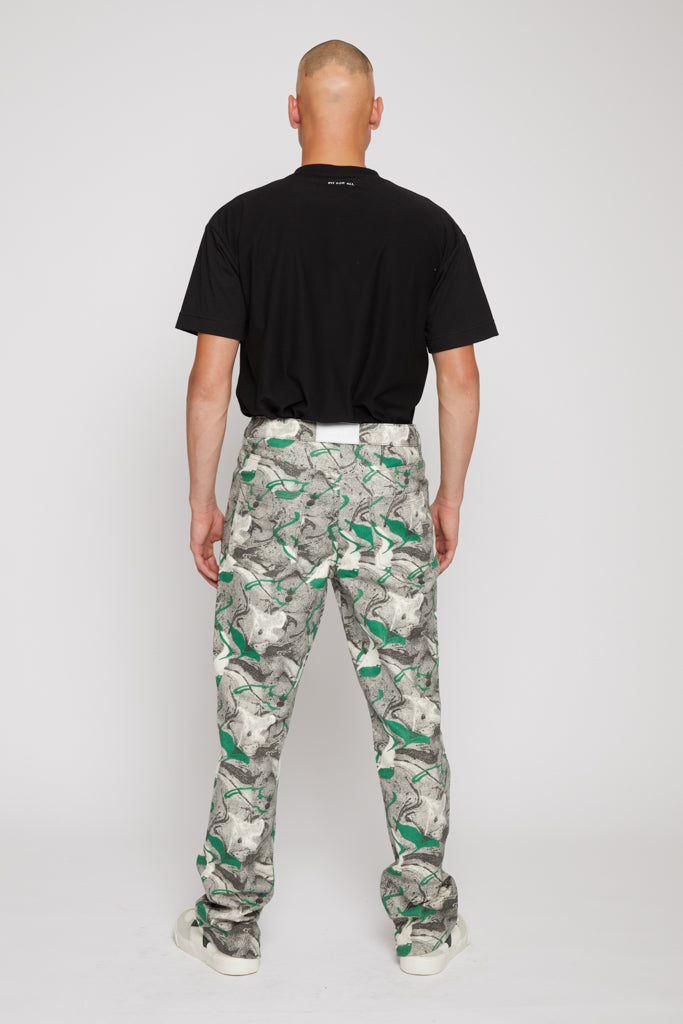 Back view of a model in the men's jeans with a green psychedelic print.