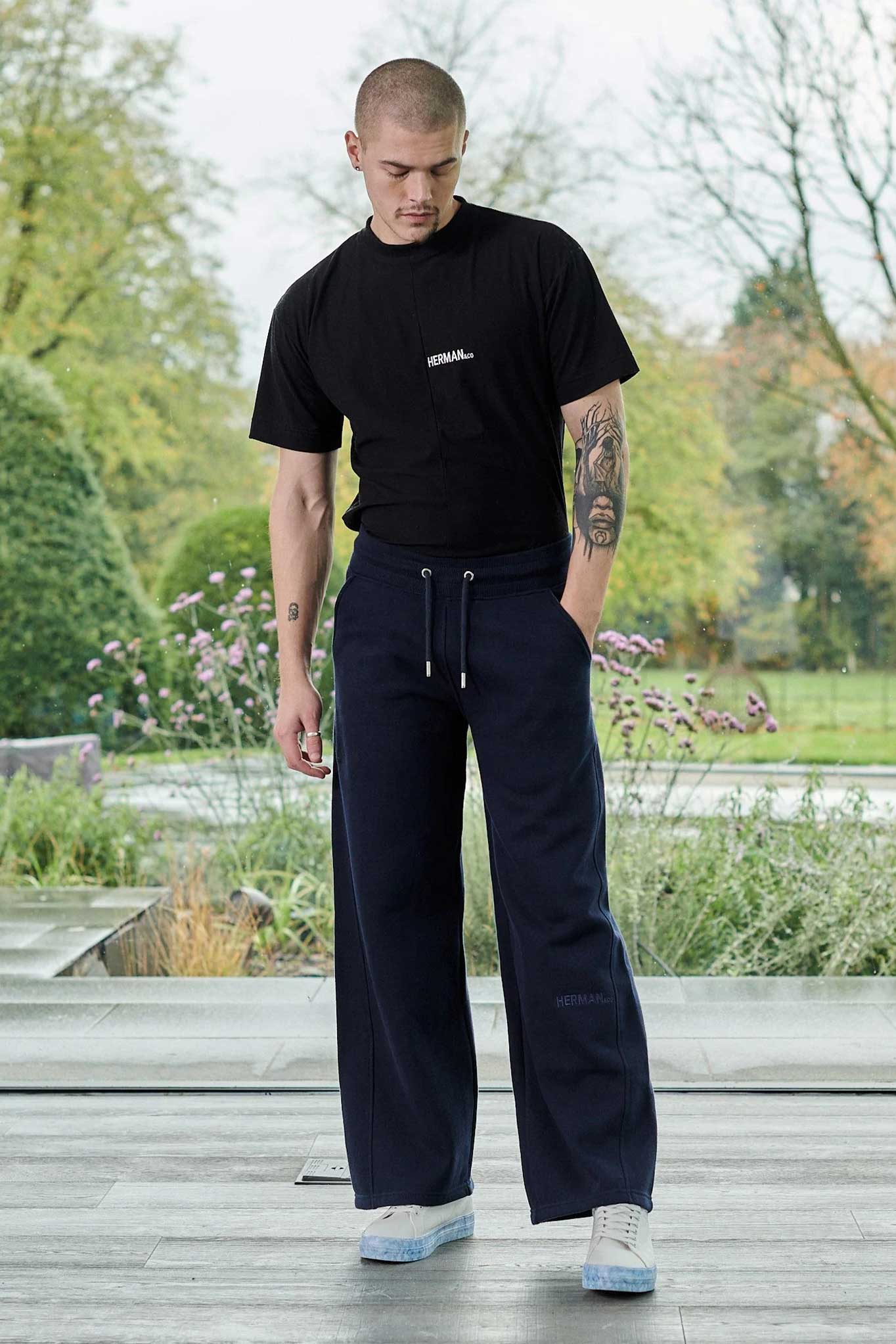 A model wearing the men's navy wide-leg joggers with a black t-shirt
