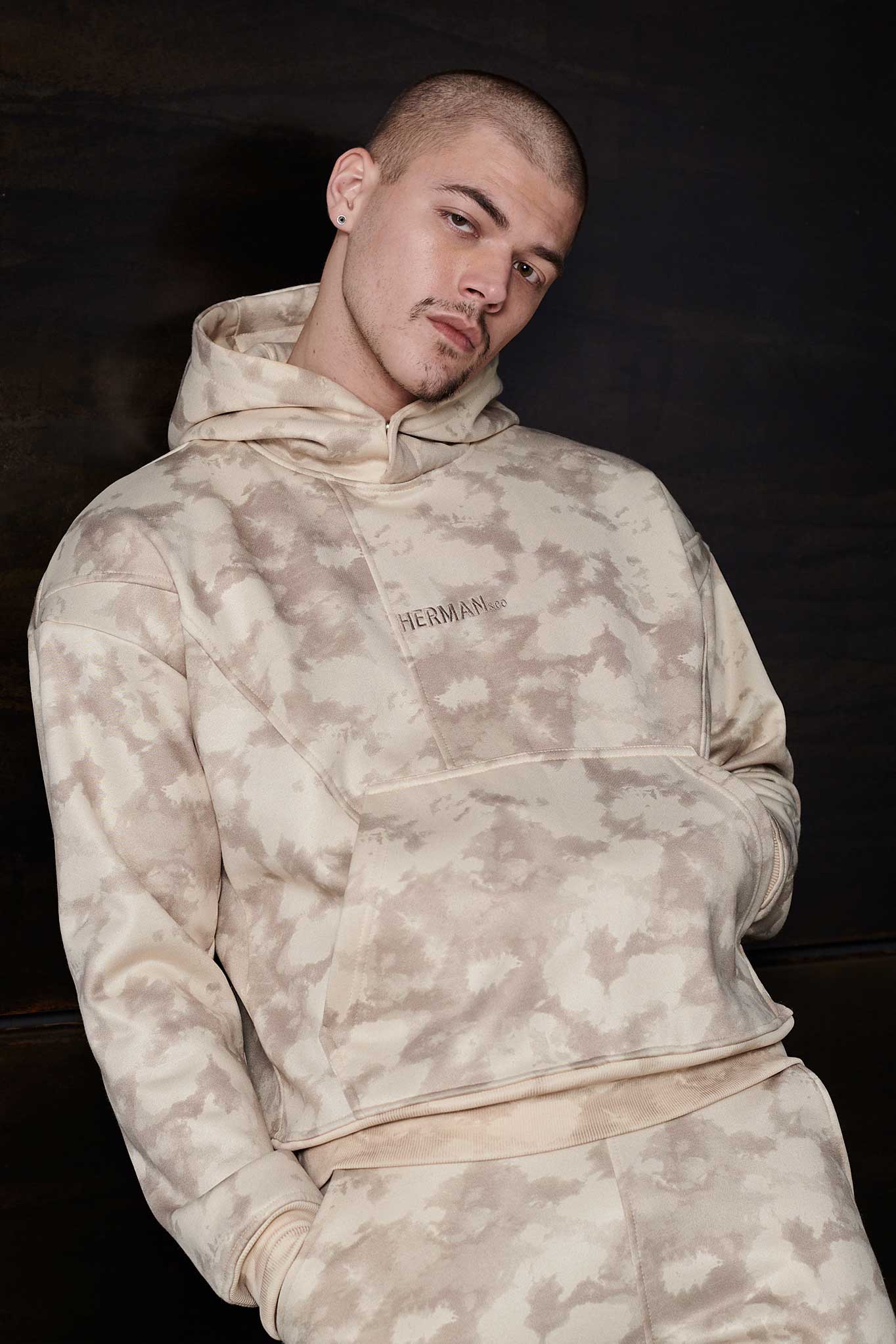 Model wearing a stylish beige mens tie dye hoodie in streetwear style