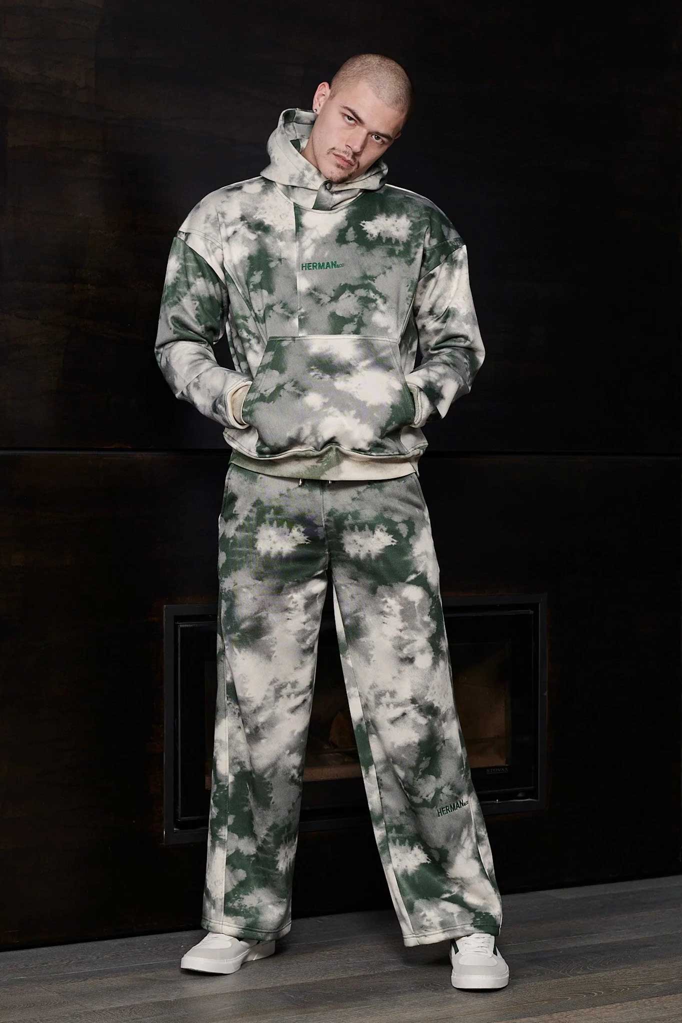 Model wearing a stylish green mens tie dye hoodie with hands in pockets