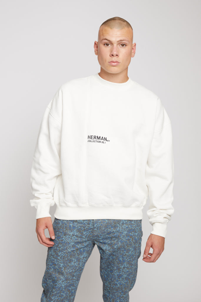 Front view of model wearing white fleece crewneck sweatshirt mens with black chest logo