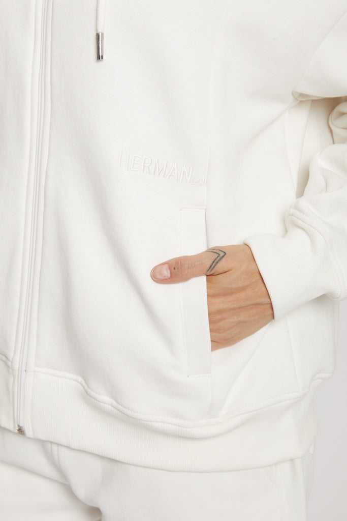 Detailed close up of the metal zipper and hood on mens white hoodie