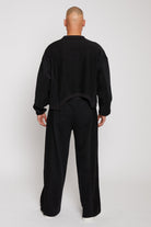 Rear full body view showing the relaxed fit of mens wide leg joggers in black