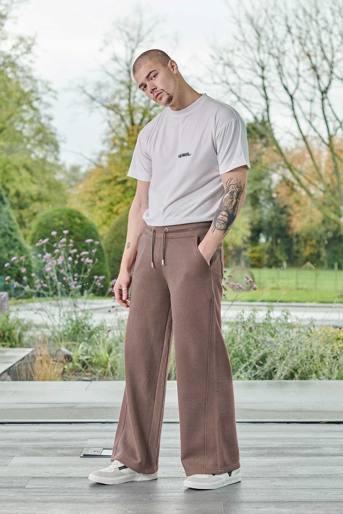 Full view of a model in the men's wide-leg joggers in brown
