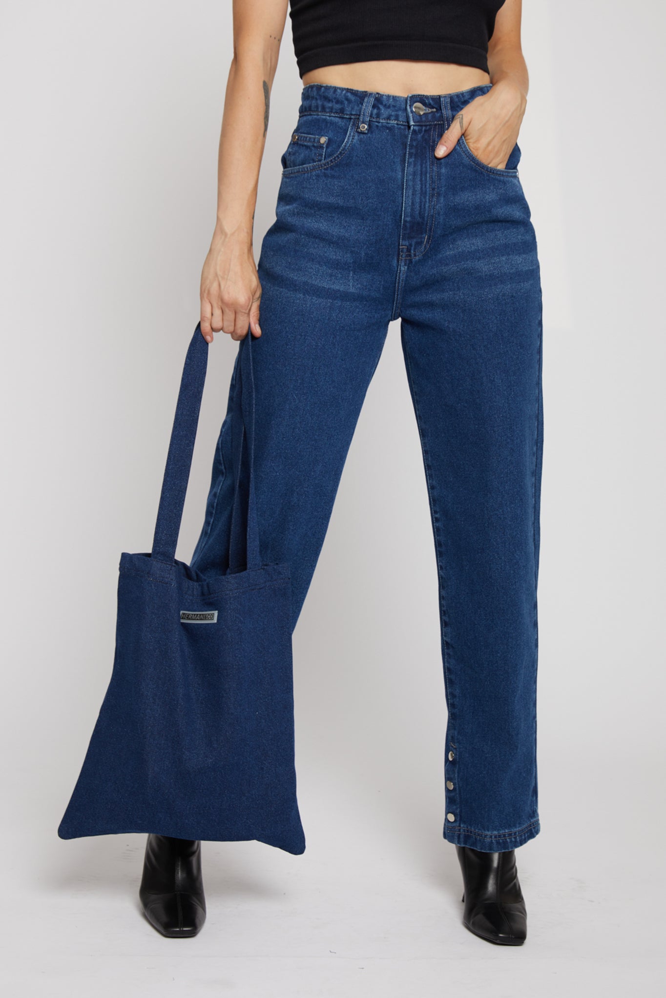A model holding the stylish and versatile dark denim tote bag.