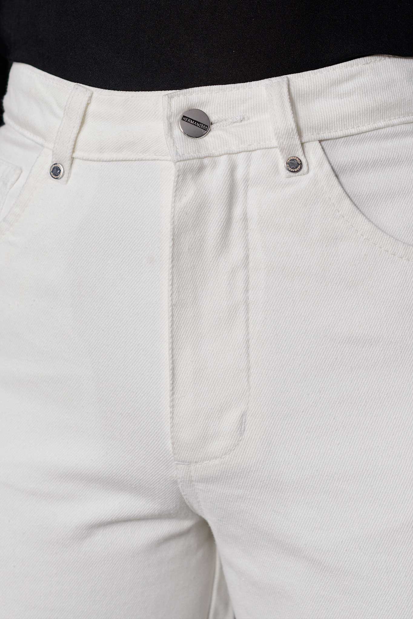 Close-up of the high waist and button fly on the off-white tapered jeans.