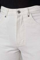 Close-up of the high waist and button fly on the off-white tapered jeans.