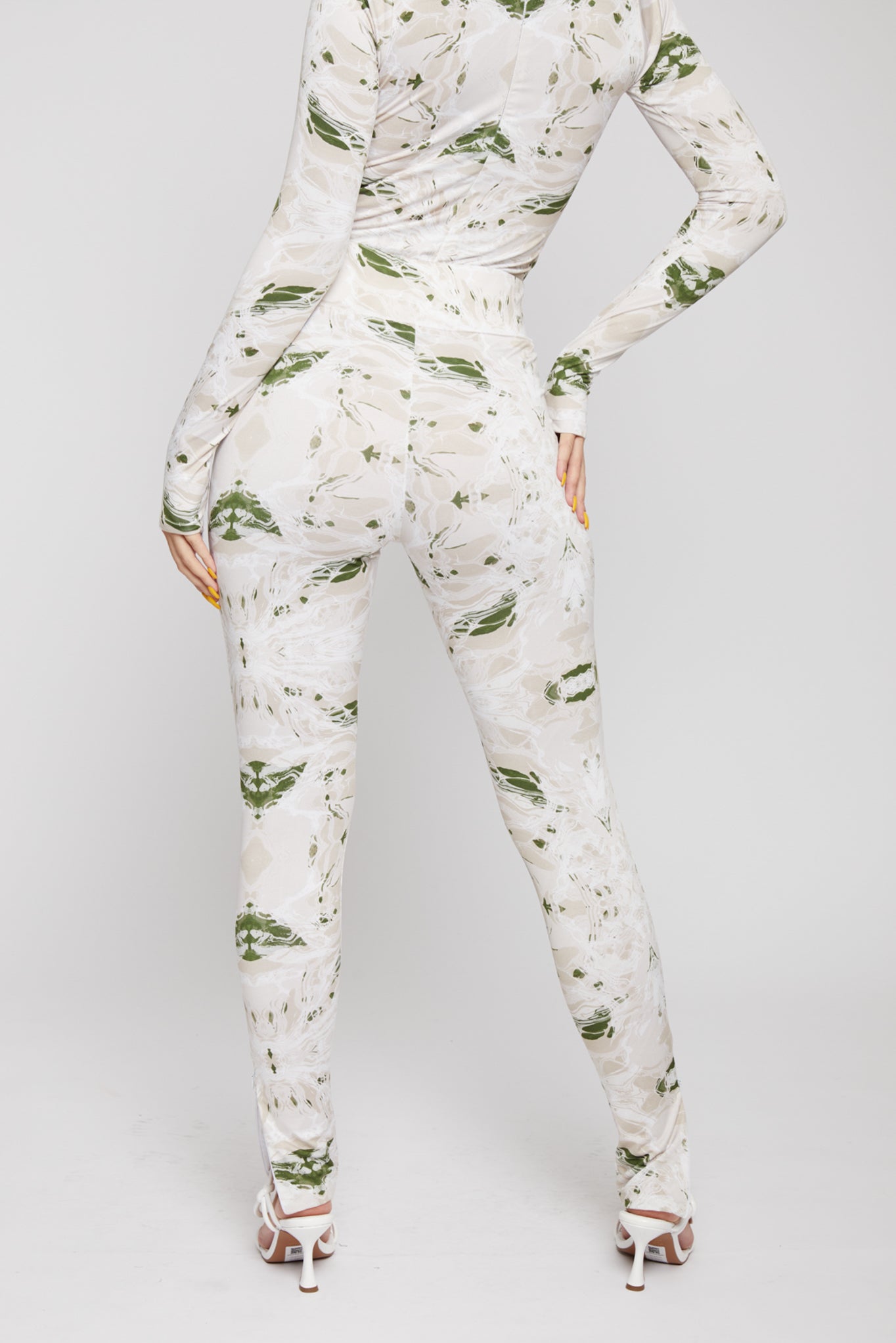 Angled back view of a model wearing the printed dipped leggings.