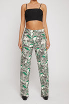 Close-up of the psychedelic printed jeans for women styled with a black crop top.