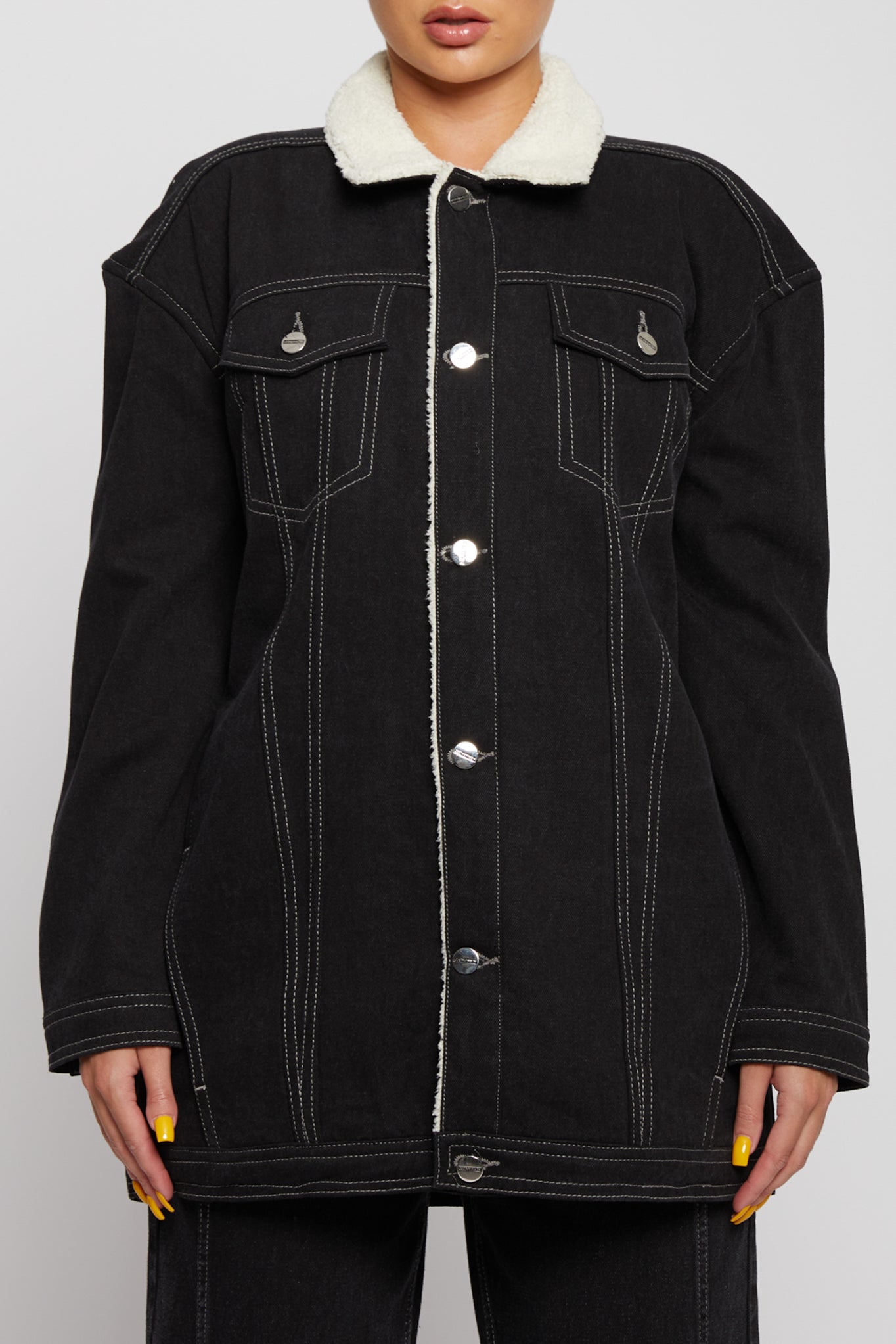 Close-up of the contrast stitching and shearling lining on the denim jacket.