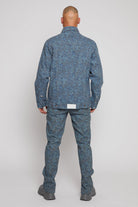 Back view of a model in the speckled print jacket and matching jeans