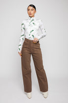 A model styled in the brown baggy jeans for women with a printed top.