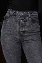 A model styling the grey distressed mom jeans for a complete streetwear look