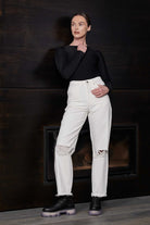 A model styled in the off-white distressed tapered jeans.