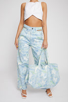 A model styled with the psychedelic jeans and a matching printed tote bag.