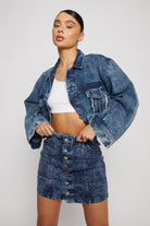 A model styled in the acid wash cropped denim jacket and matching skirt.