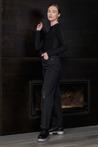 A model showing how to style the women's black ribbed bodysuit.