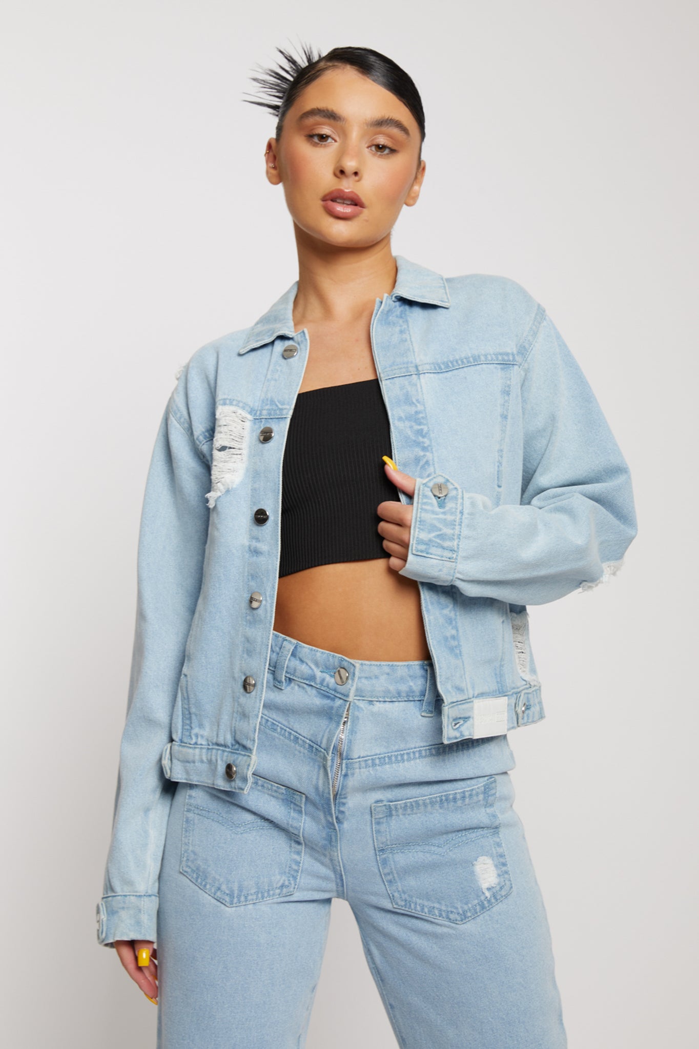 A model styled in the light wash distressed denim jacket and matching jeans.