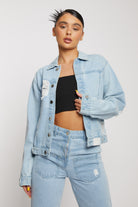 A model styled in the light wash distressed denim jacket and matching jeans.