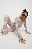 A model posing on the floor in the printed flare leggings and matching top.