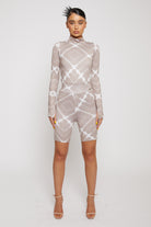 A model wearing the full taupe and white printed cycling shorts and long-sleeve top set.