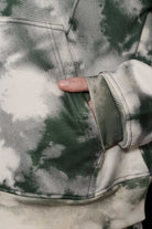 Close up texture view of the ribbed cuff and abstract print on green hoodie