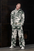 A model wearing the tie-dye joggers for men with a matching hoodie.