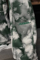 Close-up of the embroidered logo detail on the tie-dye oversized joggers.