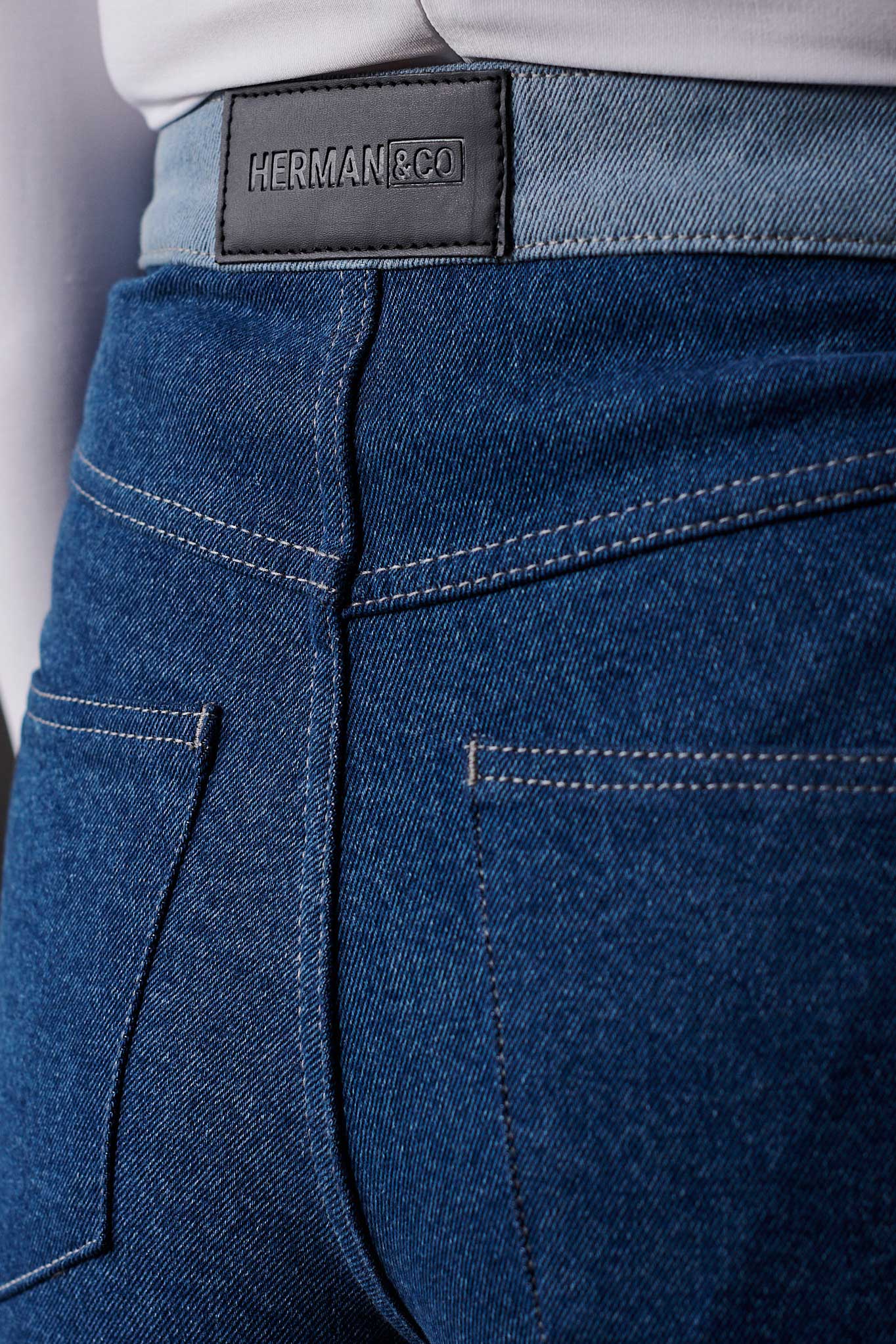 Close-up of the back pockets and logo patch on the two-tone jeans.