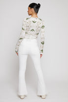 Back view of a model wearing the white high-waisted flared jeans.