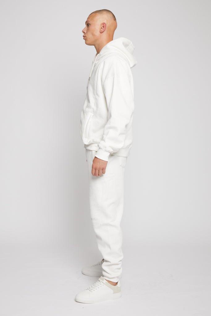 Side profile of model in a relaxed fit mens white hoodie zip up